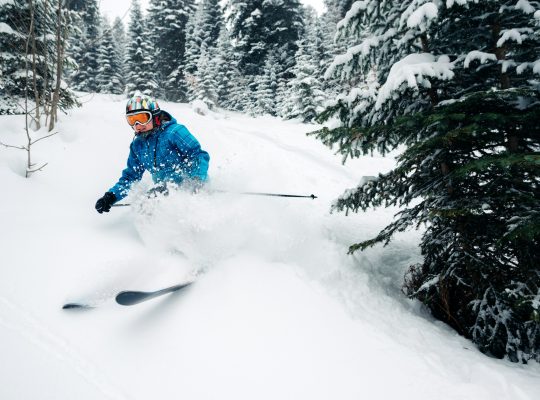 girl with special ski equipment is riding and jumping very fast in the mountain forest